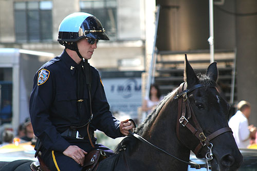 Some guy in uniform and mirrored shades riding a horse